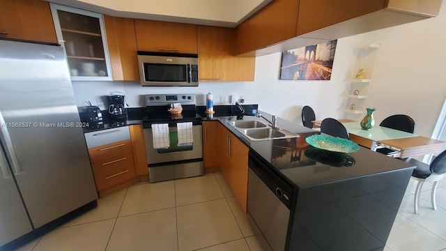 kitchen featuring kitchen peninsula, stainless steel appliances, light tile floors, and sink