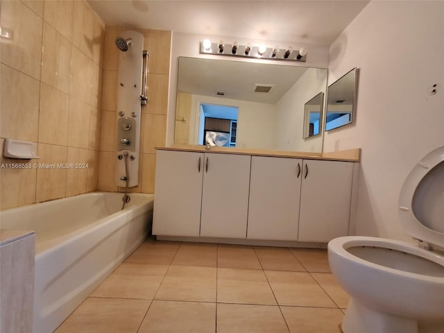 full bathroom featuring tiled shower / bath, toilet, and tile floors