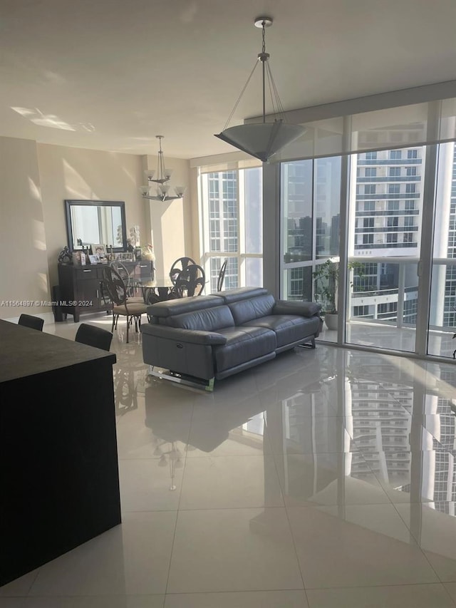 tiled living room featuring an inviting chandelier and expansive windows