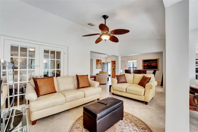 tiled living room featuring a textured ceiling, ceiling fan, french doors, and lofted ceiling