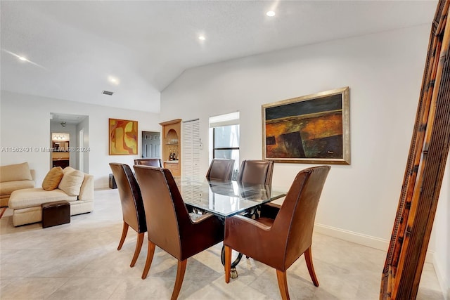 tiled dining space with vaulted ceiling