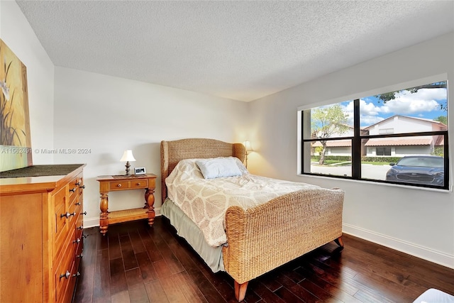 bedroom featuring dark hardwood / wood-style flooring and a textured ceiling