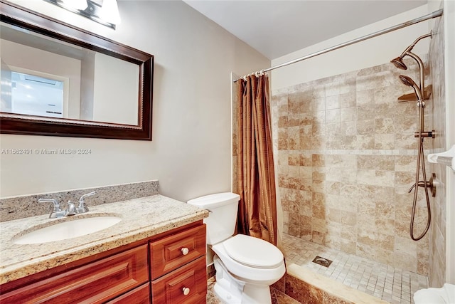 bathroom with walk in shower, toilet, and vanity with extensive cabinet space