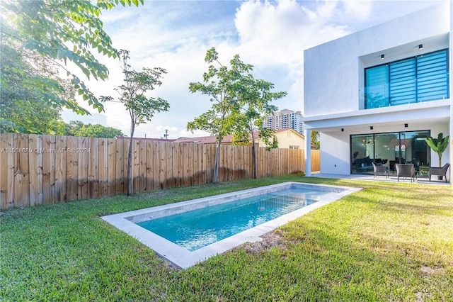 view of pool featuring a patio and a yard