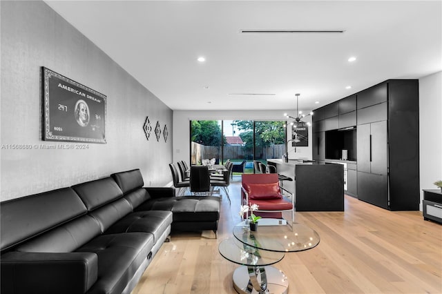 living room with an inviting chandelier and light wood-type flooring