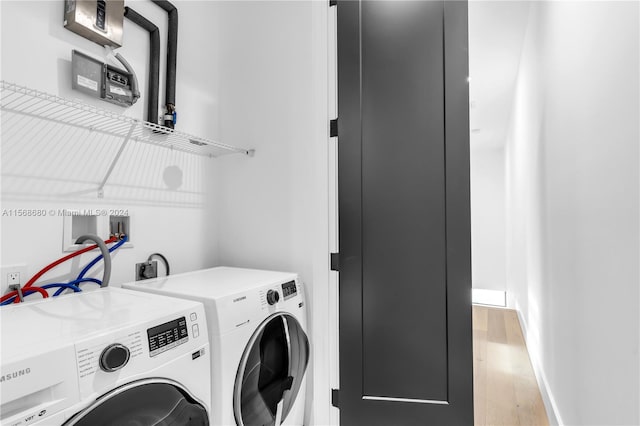 laundry area featuring independent washer and dryer and light hardwood / wood-style floors