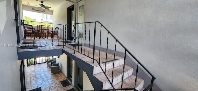 stairway with ceiling fan and light tile flooring