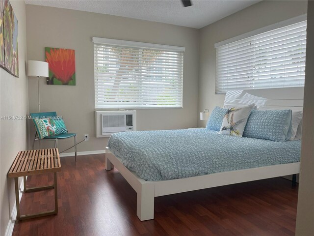 bedroom with a textured ceiling and dark wood-type flooring