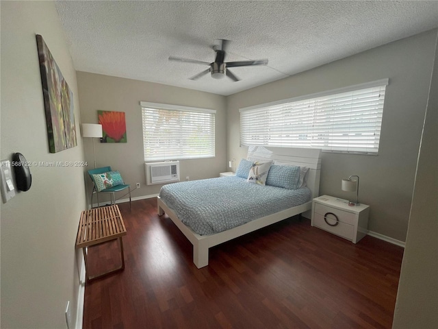 bedroom featuring dark hardwood / wood-style flooring, ceiling fan, an AC wall unit, and a textured ceiling