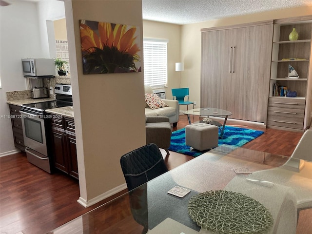 dining area with dark hardwood / wood-style floors and a textured ceiling