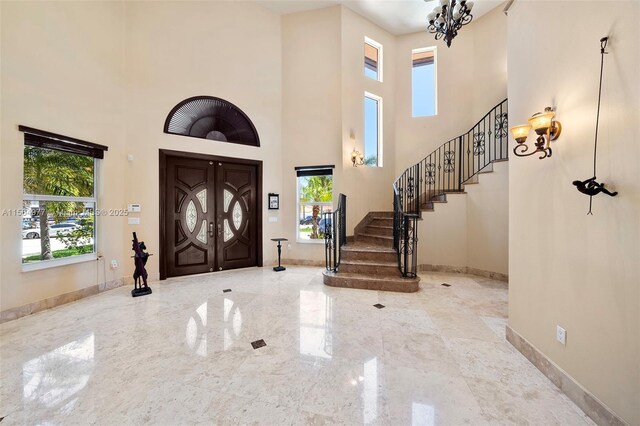 entryway featuring a towering ceiling and an inviting chandelier