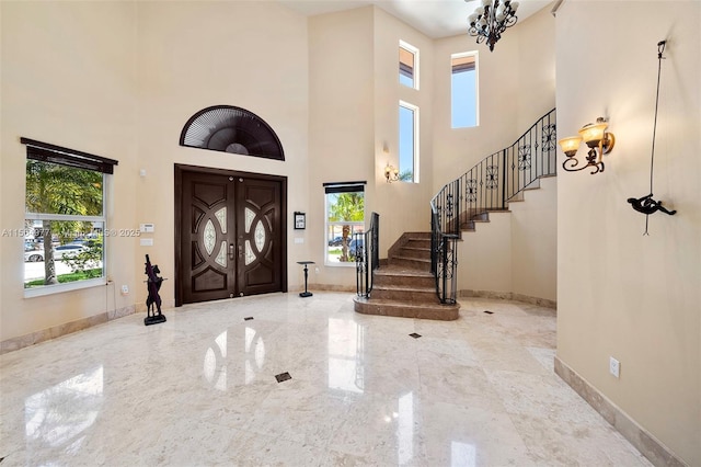 foyer featuring a towering ceiling and plenty of natural light