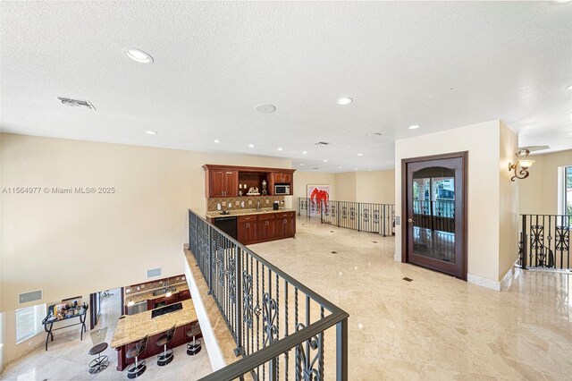 hall featuring a textured ceiling and sink