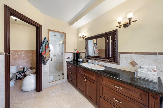 bathroom with vanity, a shower with door, tile patterned flooring, toilet, and tile walls