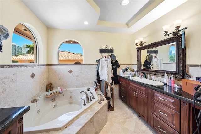 bathroom with tile patterned floors, vanity, tiled bath, and tile walls