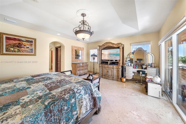 bedroom with a tray ceiling and access to exterior