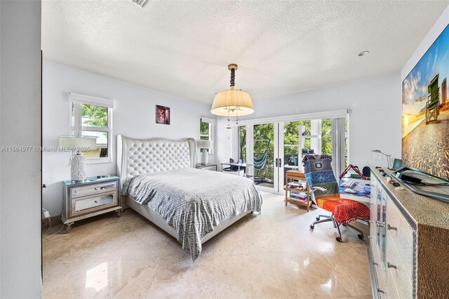 bedroom featuring access to outside, french doors, and a textured ceiling