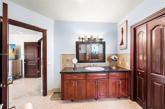 bathroom with decorative backsplash, a textured ceiling, vanity, and tile patterned flooring