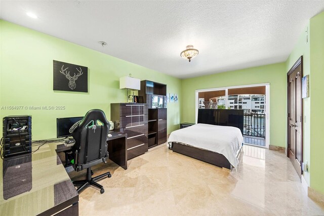 bedroom featuring access to outside and a textured ceiling