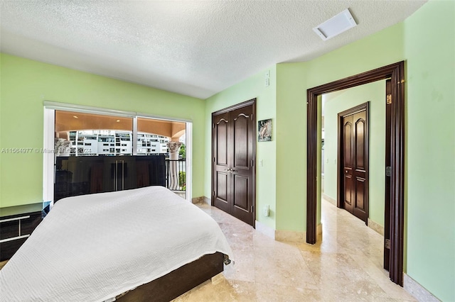 bedroom featuring access to exterior and a textured ceiling