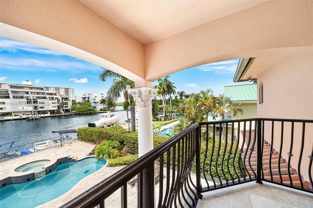 balcony featuring an in ground hot tub and a water view