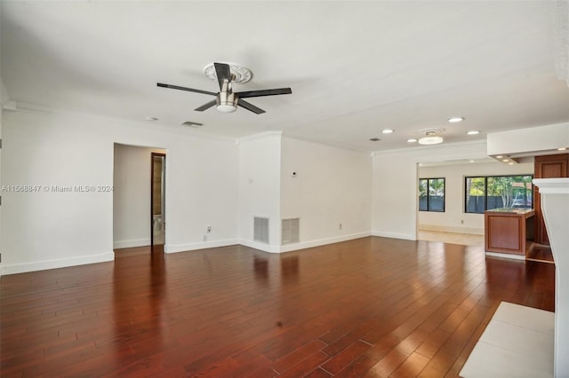 unfurnished living room with ceiling fan, dark wood-type flooring, and crown molding