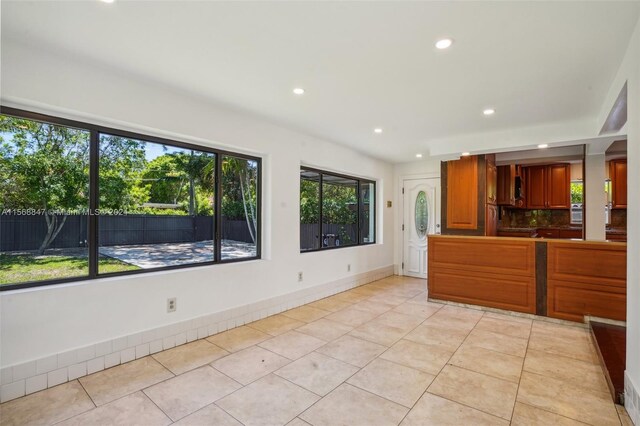 kitchen with light tile patterned floors, backsplash, and plenty of natural light