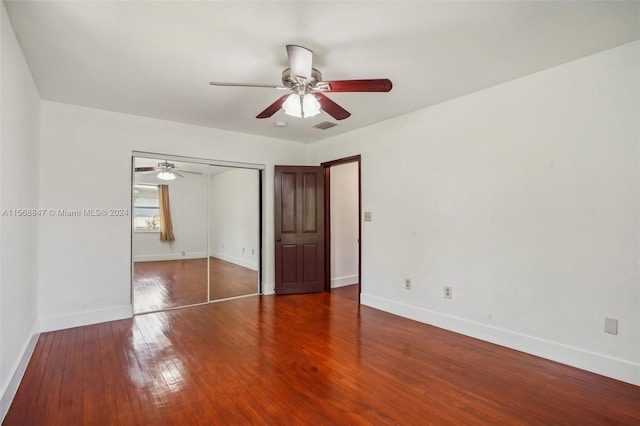 unfurnished bedroom with ceiling fan, a closet, and wood-type flooring