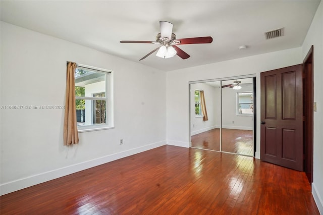 unfurnished bedroom featuring ceiling fan, dark hardwood / wood-style floors, and a closet