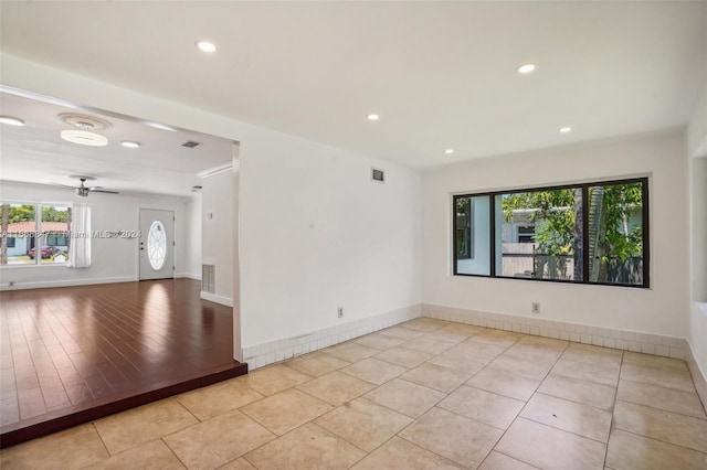 empty room with ceiling fan and light tile patterned flooring