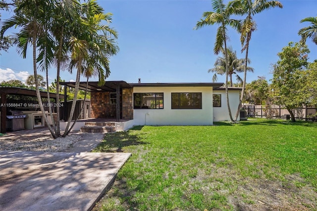 rear view of property with a lawn and a patio area