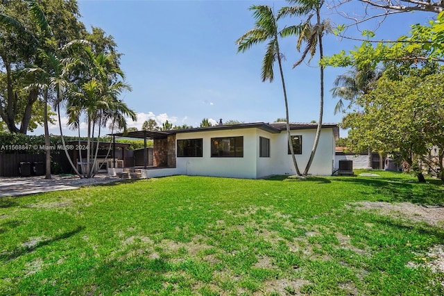 rear view of house featuring a patio area, cooling unit, and a yard