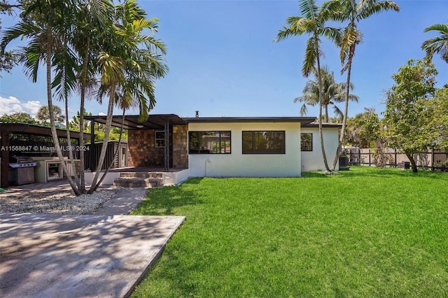 rear view of house with a yard and a patio