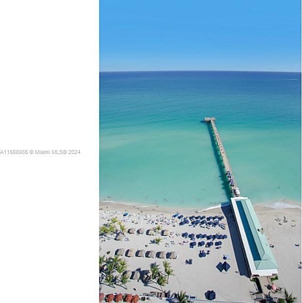 aerial view with a water view and a beach view