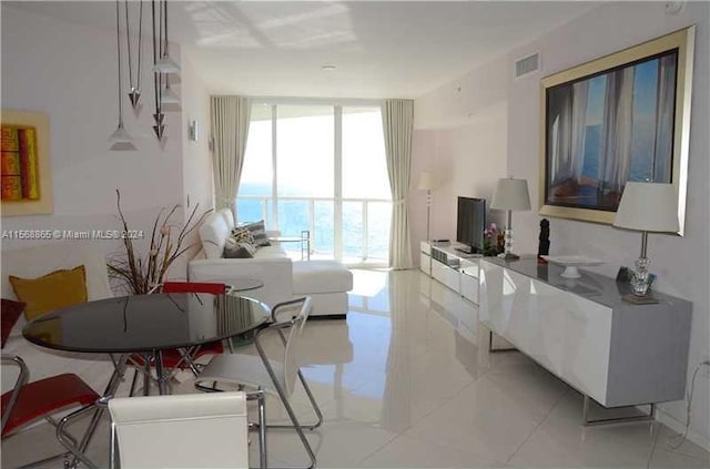 tiled living room featuring floor to ceiling windows