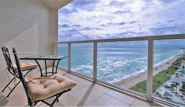 balcony featuring a beach view and a water view