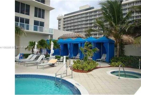 view of swimming pool with a patio and a hot tub