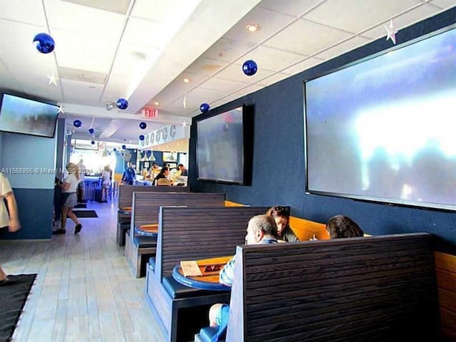 interior space with a drop ceiling and light hardwood / wood-style flooring