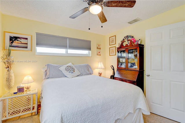 tiled bedroom with a textured ceiling and ceiling fan