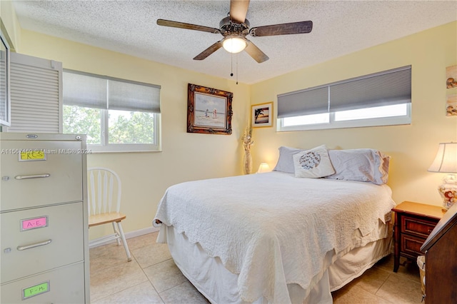 tiled bedroom featuring ceiling fan and a textured ceiling