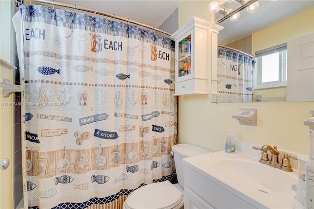 bathroom with curtained shower, vanity, and toilet