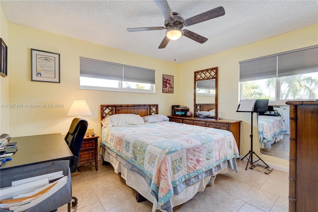 bedroom with multiple windows, ceiling fan, and a textured ceiling