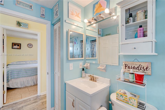 bathroom featuring vanity, hardwood / wood-style flooring, and toilet