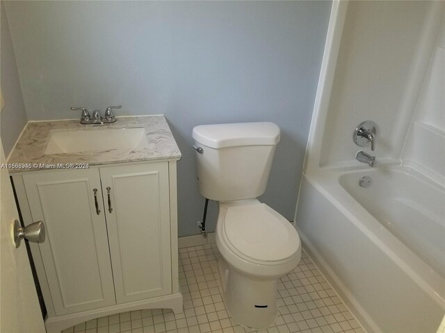 full bathroom with tile flooring, washtub / shower combination, vanity, and toilet