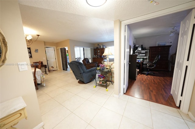 tiled living room featuring ceiling fan and a textured ceiling