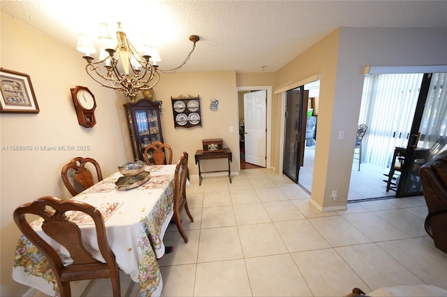 dining area with light tile patterned floors, a notable chandelier, and a textured ceiling