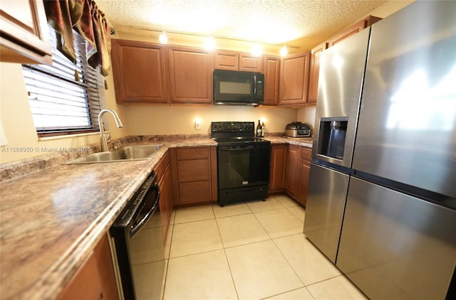 kitchen featuring light tile patterned flooring, sink, a textured ceiling, and black appliances