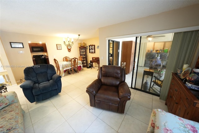 living room with ceiling fan with notable chandelier and light tile floors