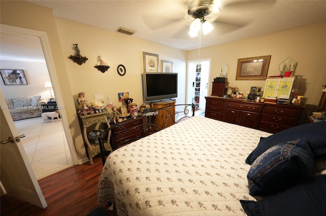 tiled bedroom with a textured ceiling and ceiling fan