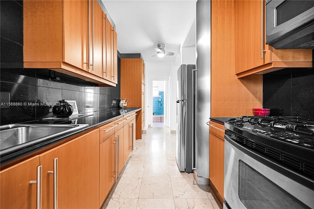 kitchen with ceiling fan, appliances with stainless steel finishes, tasteful backsplash, and sink